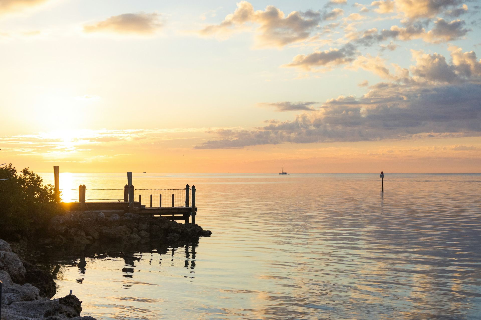 A small wooden dock on calm water at sunrise